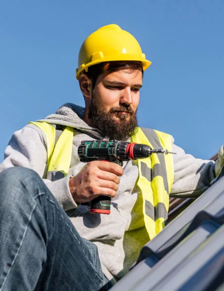 Man with drill on the roof