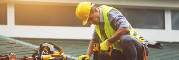 Man with drill on the roof
