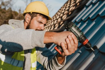 Man with drill on the roof