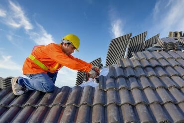 Man with drill on the roof