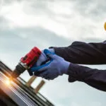 Man with drill on the roof