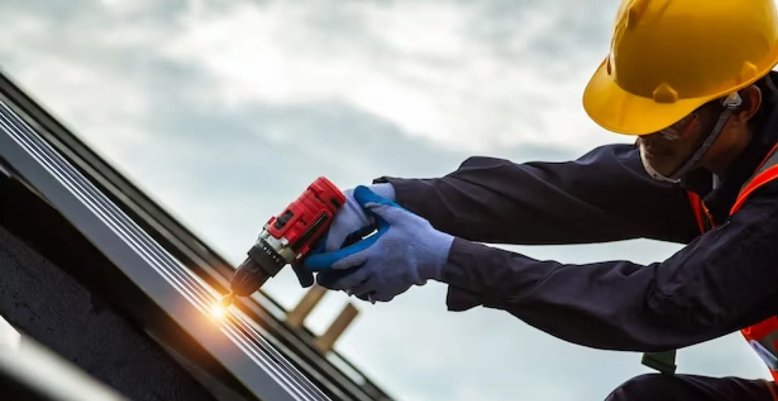 Man with drill on the roof
