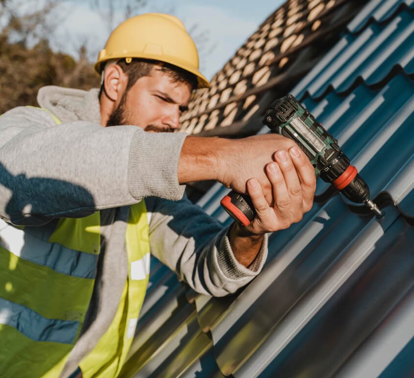 Man with drill on the roof