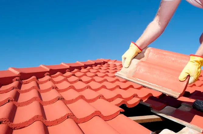 Man putting tiles on the roof